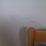 Cracked plaster behind bed